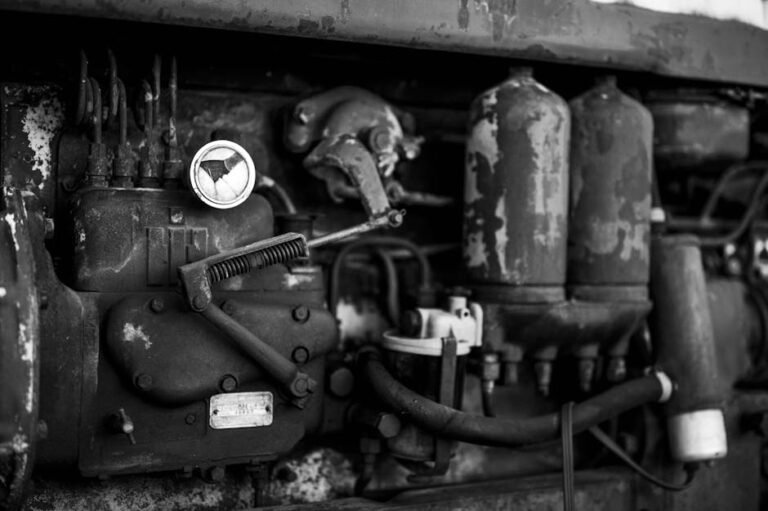 Detailed black and white close-up of vintage machinery showcasing an old engine's intricate parts.