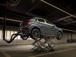 A sleek car on a lift in a high-tech automotive garage.