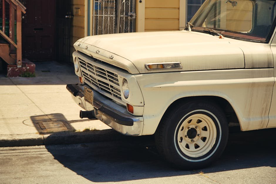 A vintage white truck parked on an urban street under daylight, showcasing classic design.