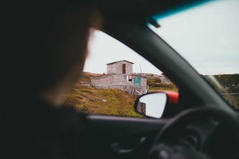 View from a car of a rustic barn in a rural area, evoking a sense of adventure and exploration.