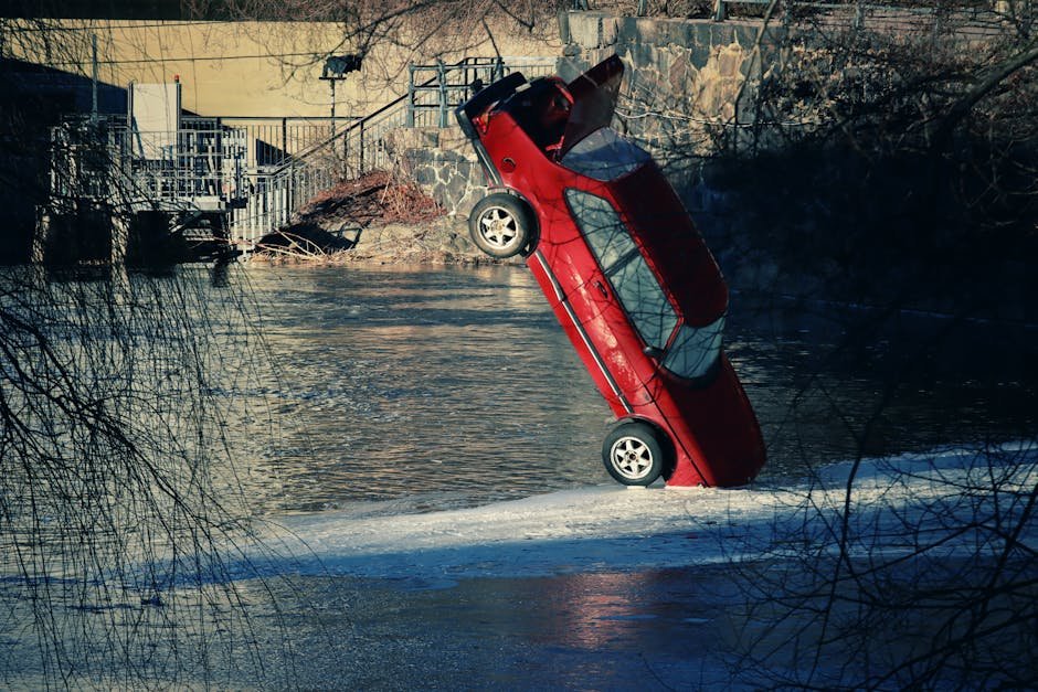 A striking image of a red car tipped into a frozen river in Sweden during winter.